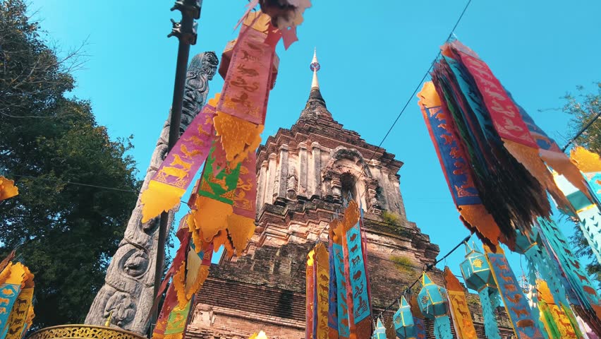 Colorful flags hanging in front of Wat Chedi Luang Open temple square Chiang Mai city center