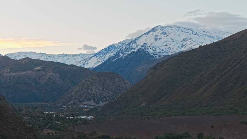 Slow aerial pan right shot of Cajon del Maipo and snow-capped mountains at dawn, Chile