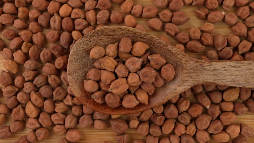 Chickpeas in a wooden spoon closeup.