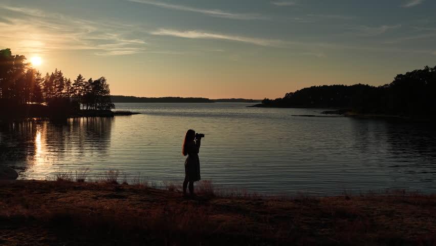 Aerial view female photographer taking pictures seaside sunset archipelago