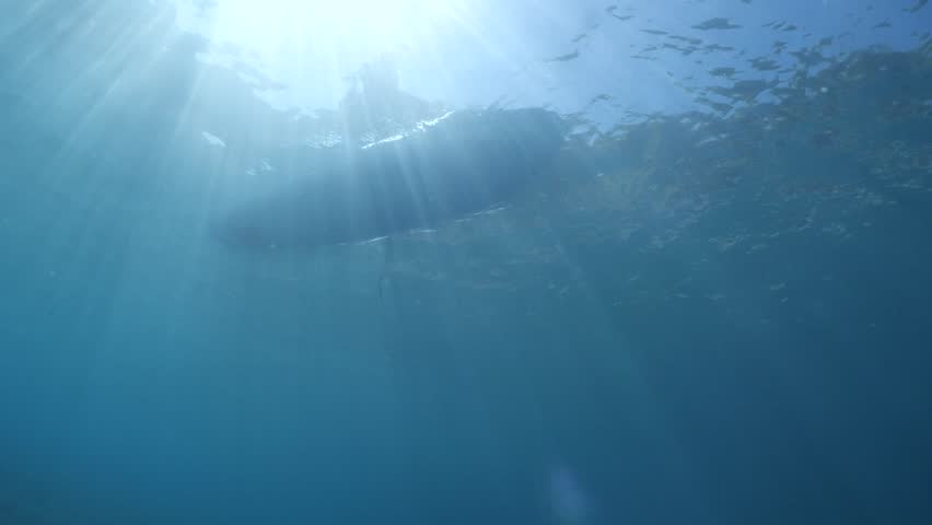 An underwater shot of a sea kayak paddling across the ocean surface cano