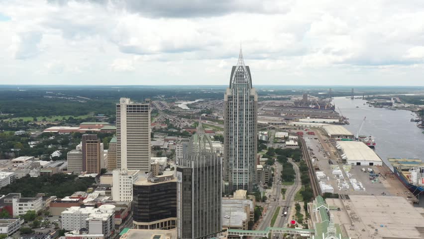 4K aerial drone footage showcasing the downtown skyline of Mobile, Alabama on a clear afternoon, highlighting the city