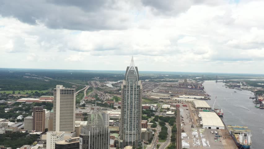 High-resolution aerial footage capturing downtown Mobile, Alabama with sweeping views of the city skyline, waterfront, and surrounding commercial district.