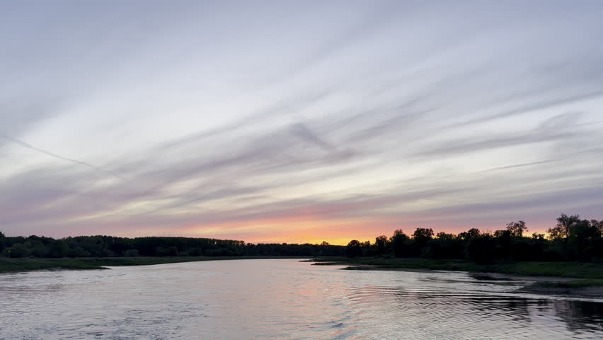 Tracking shot from moving boat shows beautiful sunset over the Elbe River in Germany. 