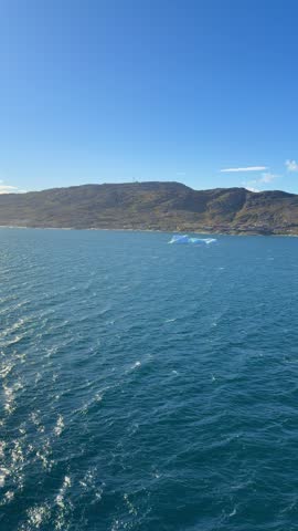 The fjords, mountains, and icebergs near the town of Qaqortoq, Greenland on a bright sunny day.