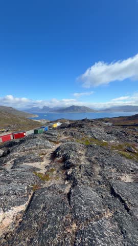 The fjords, mountains, and icebergs near the town of Qaqortoq, Greenland on a bright sunny day.