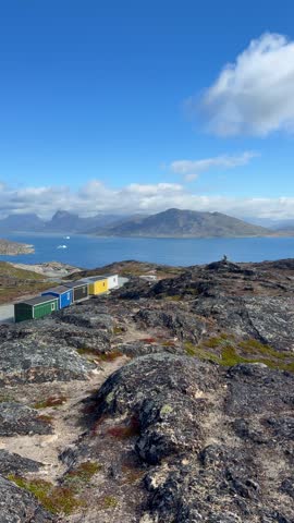The fjords, mountains, and icebergs near the town of Qaqortoq, Greenland on a bright sunny day.