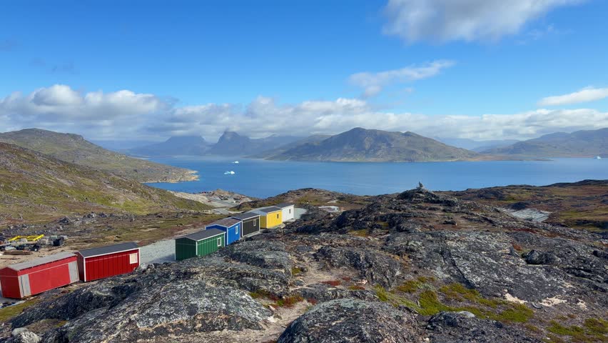 The fjords, mountains, and icebergs near the town of Qaqortoq, Greenland on a bright sunny day.