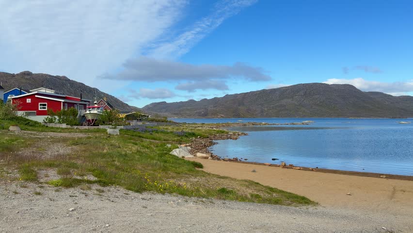The fjords, mountains, and icebergs near the town of Qaqortoq, Greenland on a bright sunny day.