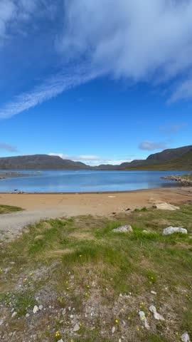 The fjords, mountains, and icebergs near the town of Qaqortoq, Greenland on a bright sunny day.