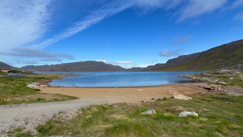 The fjords, mountains, and icebergs near the town of Qaqortoq, Greenland on a bright sunny day.