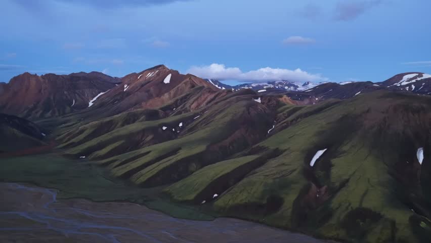 Stunning aerial drone footage of the colorful rhyolite mountains of Landmannalaugar in Iceland’s Highlands. Vibrant volcanic slopes, patches of snow, winding valleys, and untouched wilderness create one of the country’s most iconic natural landscapes.
