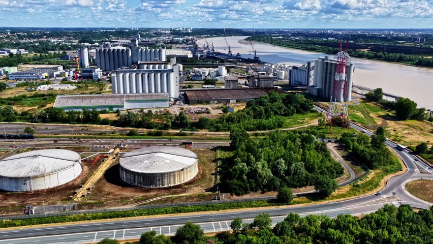 Industrial oil terminal near the Port of Bordeaux in Bordeaux, France, featuring cylindrical storage tanks, pipelines, and energy infrastructure - drone shot