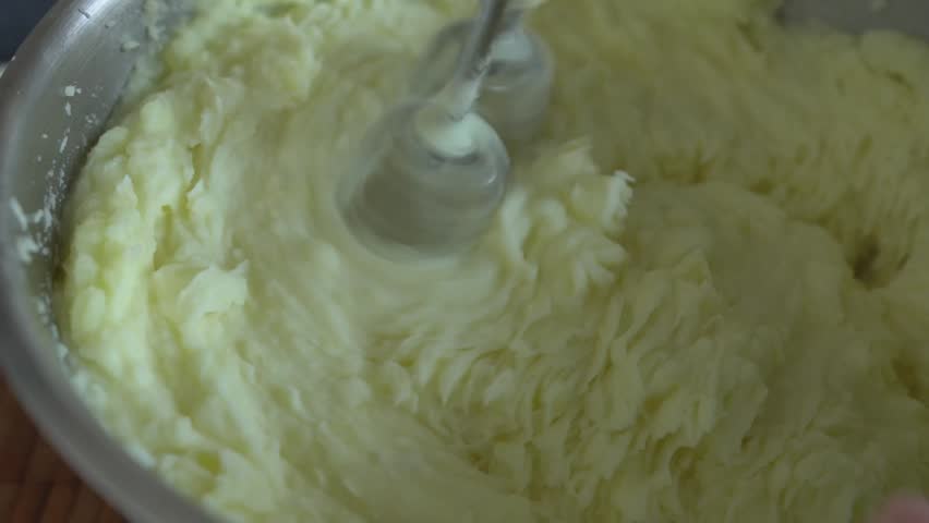 Mashed potatoes in a saucepan. Beating mashed potatoes with a mixer.