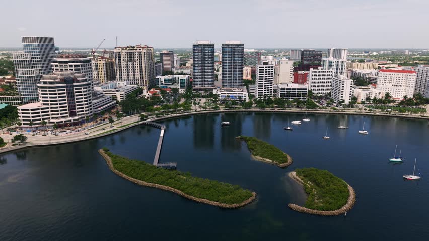 Mangrove islands and downtown West Palm Beach waterfront skyline, aerial tracking right along Flagler drive