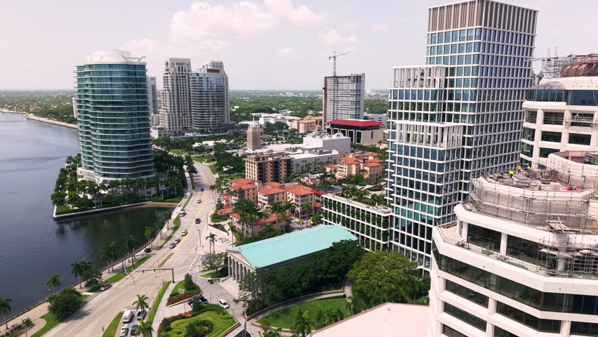 West Palm Beach downtown skyline above waterfront Flagler drive boulevard, aerial pullback reveal