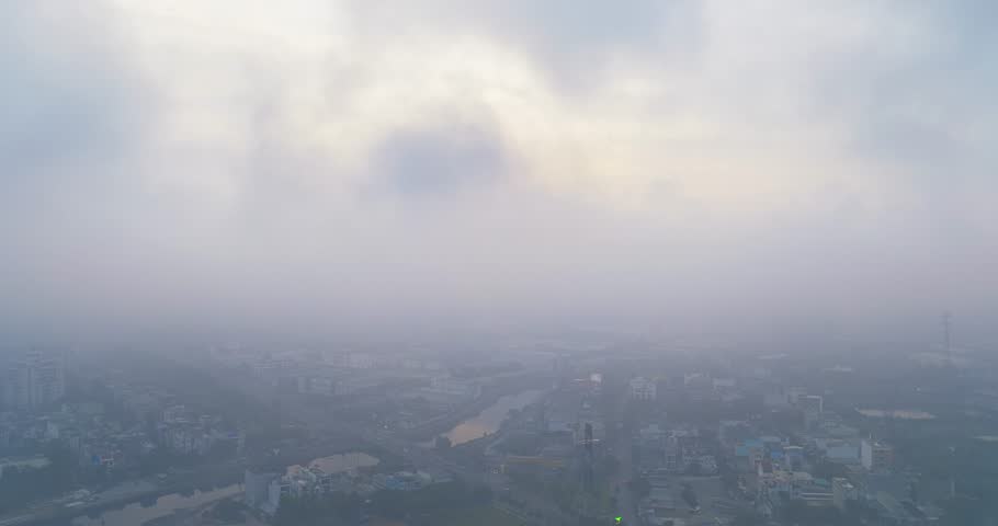 Aerial view of Saigon cityscape at morning with misty sky in Southern Vietnam. Urban development texture, transport infrastructure and green parks