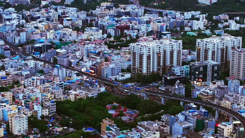 Metro train with surrounding Residential buildings and Centre For Organization Development at madhapur, hyderabad, telangana, india. day time, stable shot, drone shot, 4k.