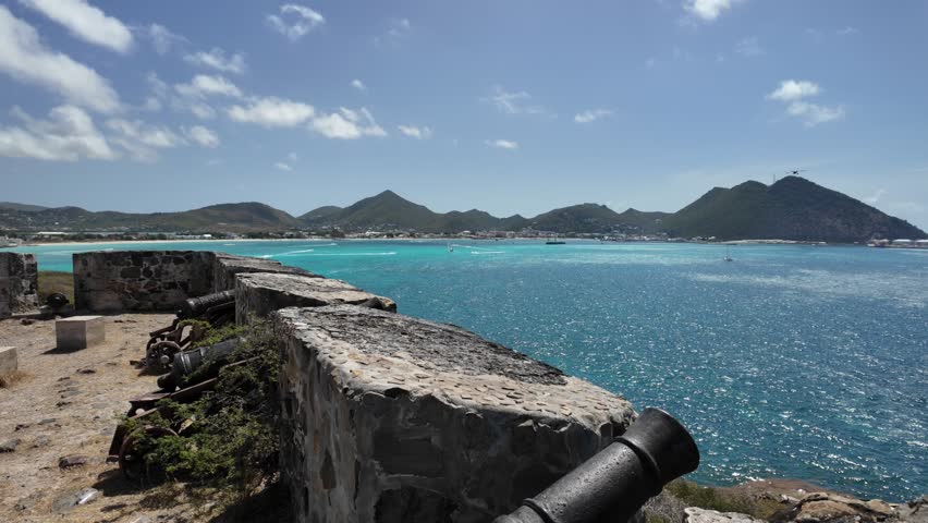 Stunning panoramic view from historic Fort Amsterdam overlooking the crystal-clear turquoise waters of Great Bay in Sint Maarten, Caribbean. Historic stone fortifications and old cannons.