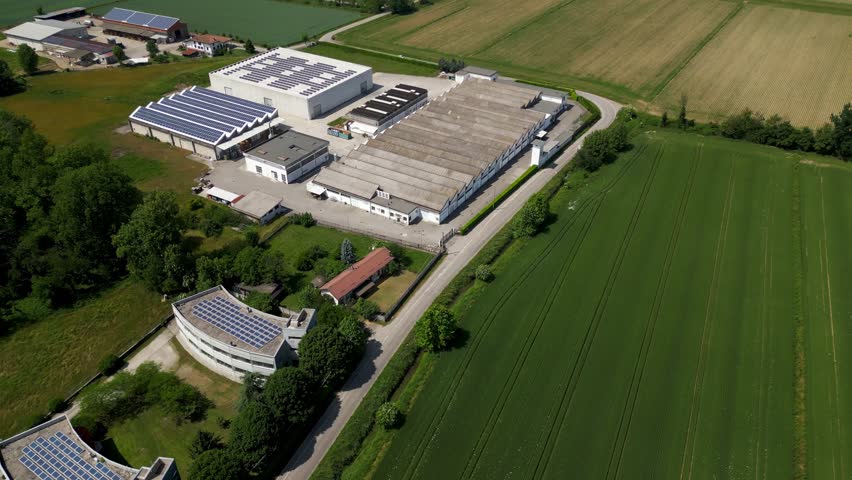 Aerial view of a paper manufacturing and packaging production facility near Milan, Italy, showing industrial processes and modern infrastructure.