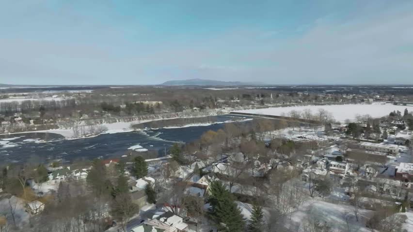 drone almost doing a 360 rotation showing the oldest part of the city of chambly in quebec canada in winter from the bridge to the fort chambly