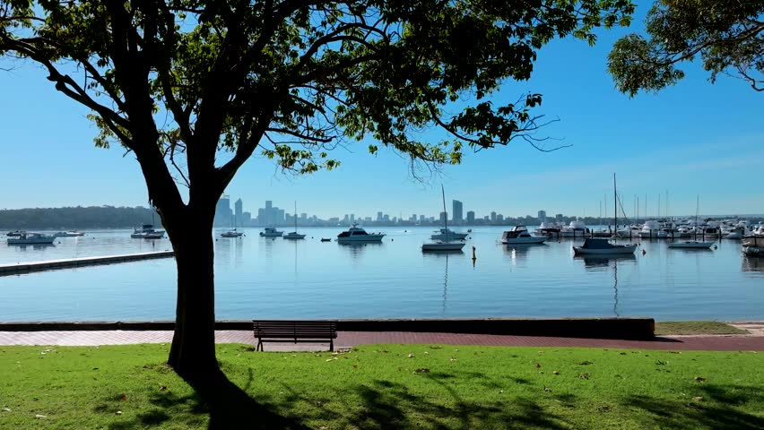 Aerial view of Matilda Bay with sailboats on calm water and Perth skyline in the distance, Crawley, Western Australia, Australia.