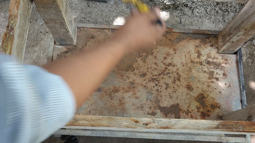 Applying First Brush Strokes of Black Paint to Rusty Metal Sheet