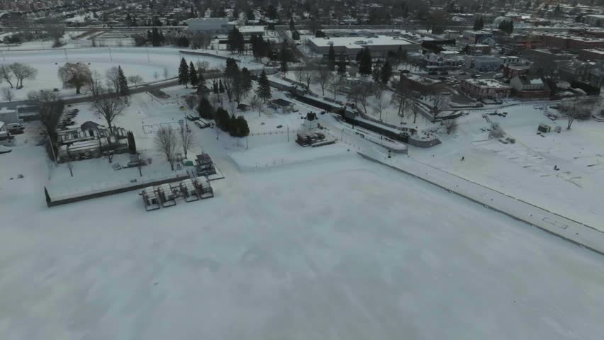 drone flying along the chambly channel a historic place in canada in the winter overlooking the new town n the marina