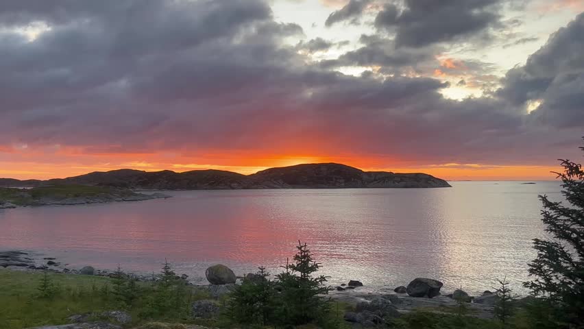 Golden sunset casting light across the calm Norwegian coast.