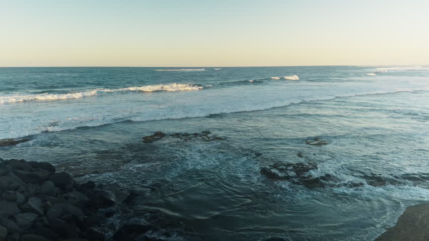 Evening waves spread across a rocky Caribbean shoreline in Puerto Rico.