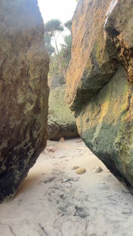 From a narrow rock crevice, revealing green coastal cliffs and the sun