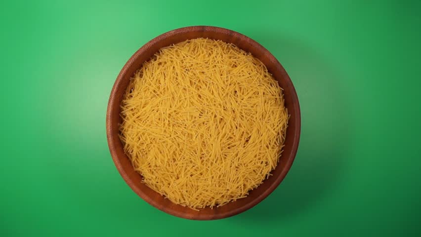Rotation of macaroni in a wooden bowl close-up