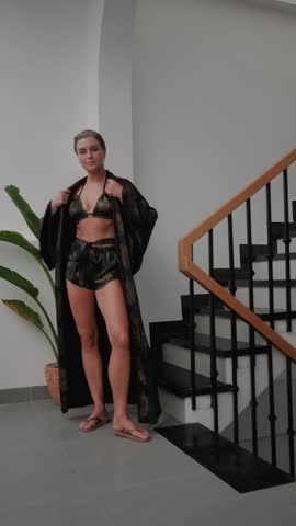Woman wearing coordinated kimono robe with matching bralette and lounge shorts.