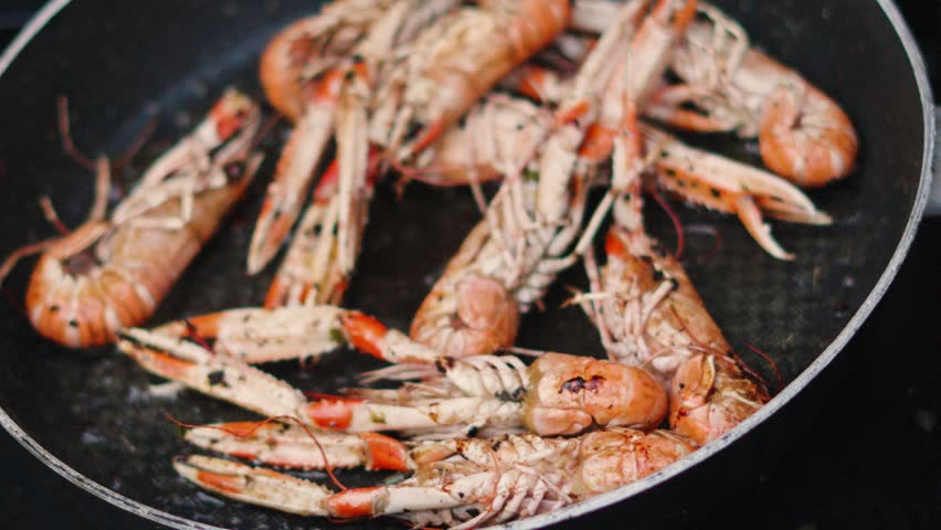 Fresh Langoustines Being Shaken Whilst Cooking in Hot Pan. Shellfish Seafood being Cooked Outdoors in Slow Motion. Norway Lobster.