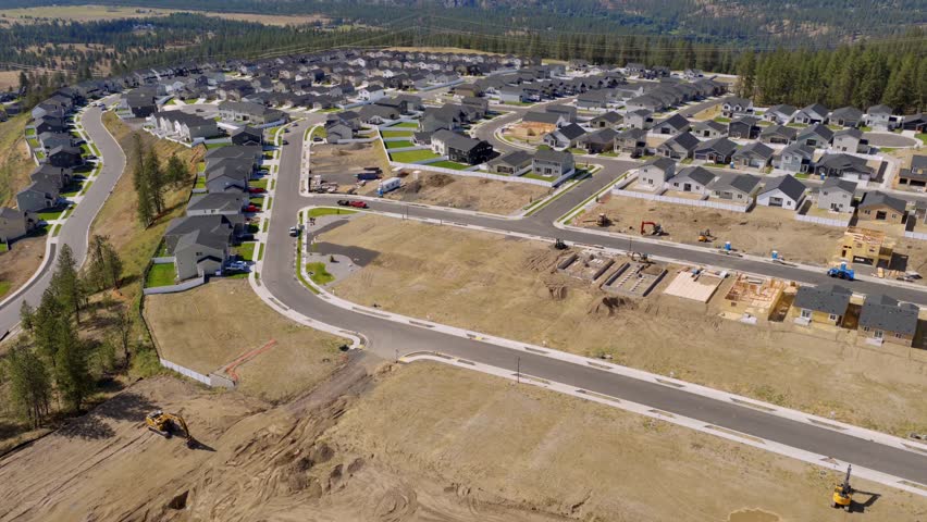Aerial view of an active construction site within a new Spokane, Washington subdivision, with homes in various stages of completion.