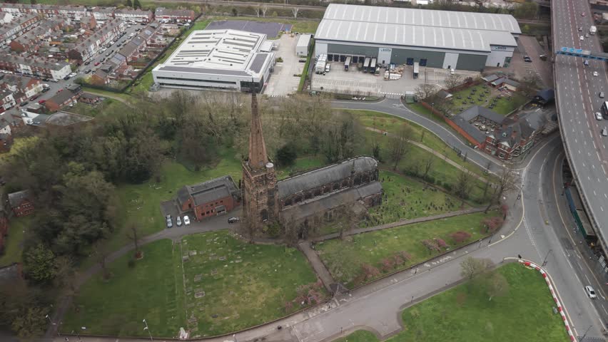 Aerial view of Aston Parish Church in Birmingham with roads, trees and nearby buildings around it.