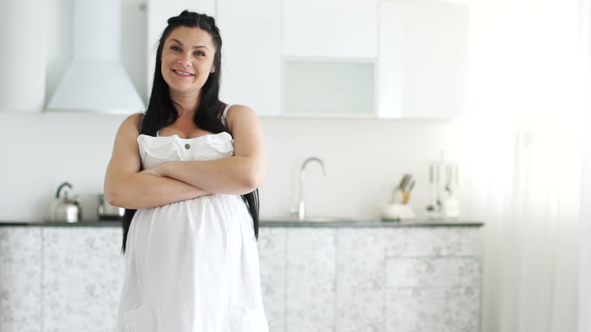Pregnant woman looking at the camera and smiling
