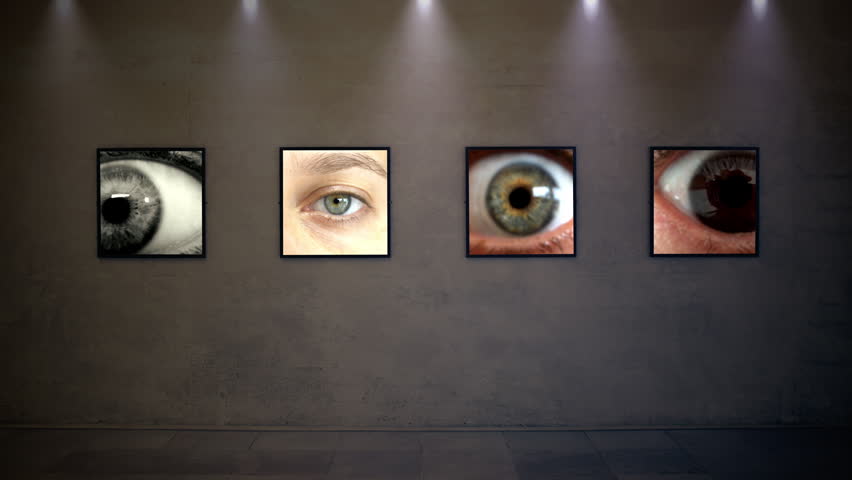 Weird Glitching Eyes Close Up Portraits Displayed on Gallery Wall Screens. Four illuminated screens on a dark gallery wall show extreme close ups of a human eye, glitching and distorting between frames like a video art installation.