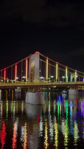 Aerial drone view of the yellow suspension bridge crossing the Allegheny River towards downtown Pittsburgh skyline in Pennsylvania