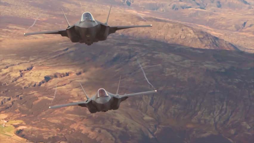 Two U.S. Air Force F-35 Lightning II Stealth Fighters Maintain Close Formation Over Rugged Mountainous Training Terrain.