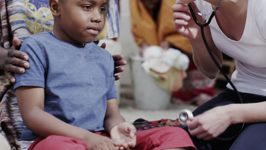 A medical worker from a charity organization chats with the mother of a young boy she has been examining. In slow motion. | Shutterstock HD Video #4150735