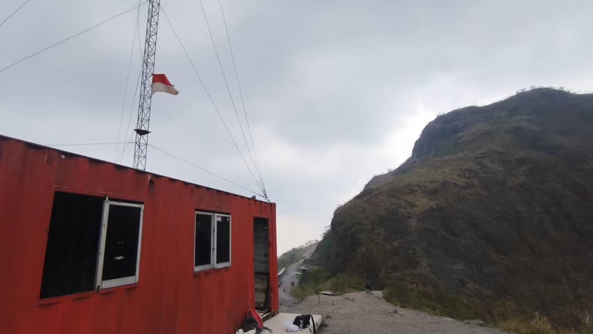 Red Tower Structure with Indonesian Flag in Mountains