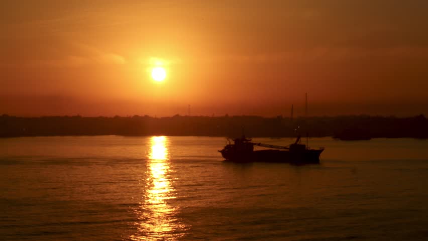 A sunrise view over the sea with a passing ship,Surabaya, August 8,2026