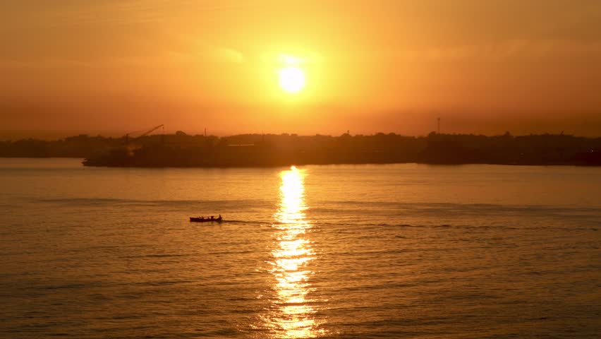 A sunrise view over the sea with a passing ship,Surabaya, August 8,2026