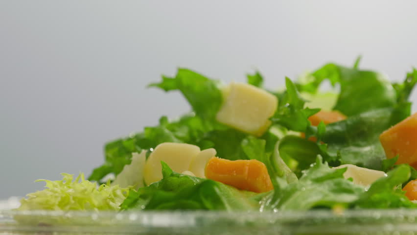 Olive, Sunflower, Avocado, Sesame, Coconut, Flaxseed Oil Pouring Over Fresh Green Caesar Salad Leaves in Bowl, Close Up of Healthy Organic Food Preparation, Restaurant and Cafe Cooking Concept