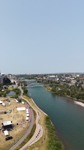 Aerial view of Calgary skyline and Bow River with urban buildings and green riverside landscape in Alberta, Canada.
