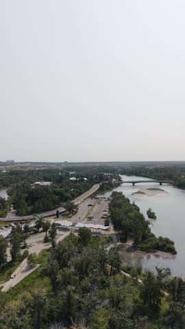 Aerial view of a river, bridge and surrounding green landscape in Calgary, Alberta, Canada.
