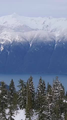 Majestic Snow-Capped Mountains Overlooking a Serene Lake and Forest in Wintery British Columbia, Canada