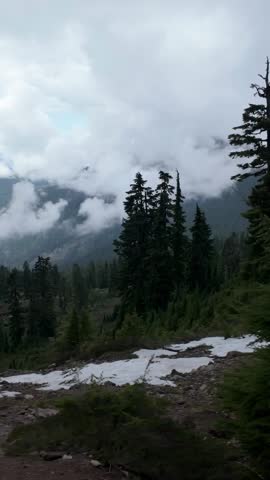 Majestic Mountain Landscape with Rolling Clouds and Evergreen Forest in British Columbia, Canada