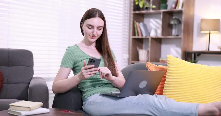 Online store shopping. Woman using smartphone and laptop at home. Camera moving